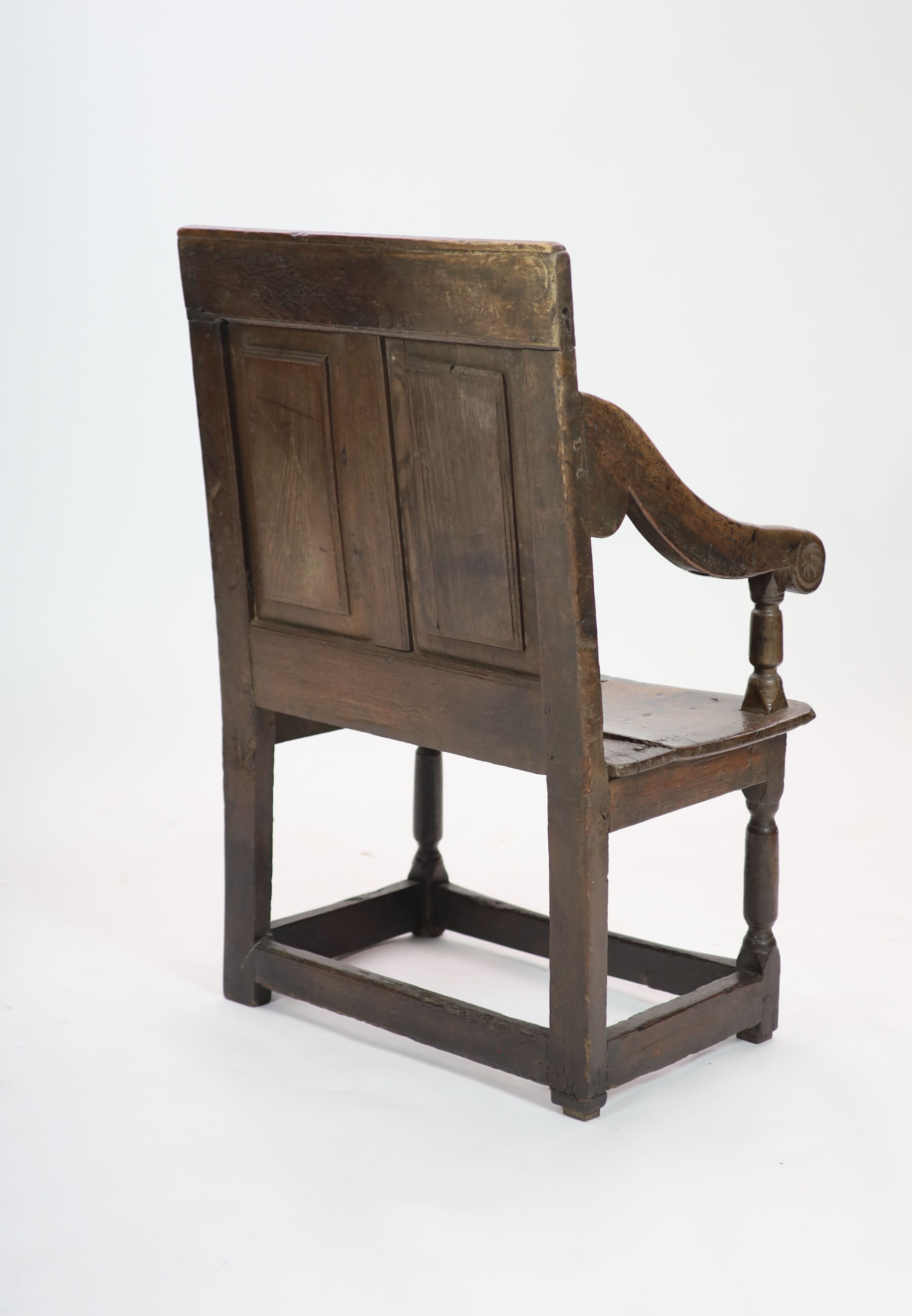 A 17th century panelled oak open armchair, the seat initialled 'PO' H 97cm. W 66cm. D 52cm.